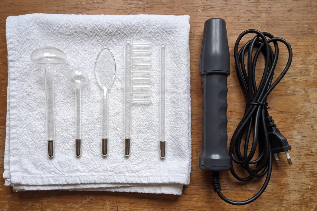 Mushroom, spot, tongue, comb and saturator glass electrodes on a dry towel beside an unplugged high frequency wand